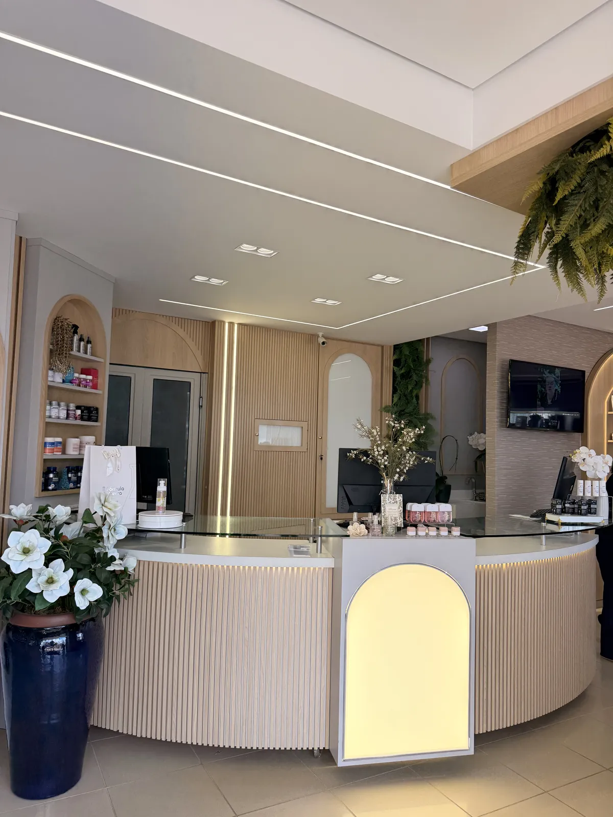 Balcão de atendimento da Fórmula Certa, com arco iluminado e plantas
